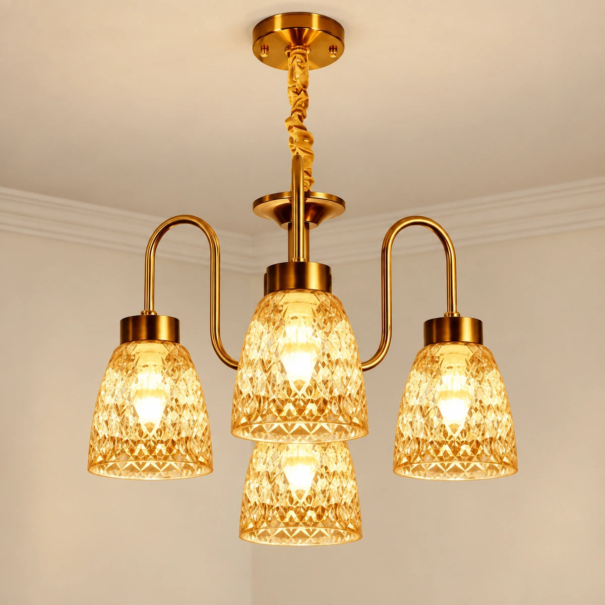 Four-light gold chandelier with patterned amber glass shades in a 3+1 arrangement