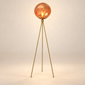 Illustration of amber globe tripod floor lamp; physical scale and light output unverified