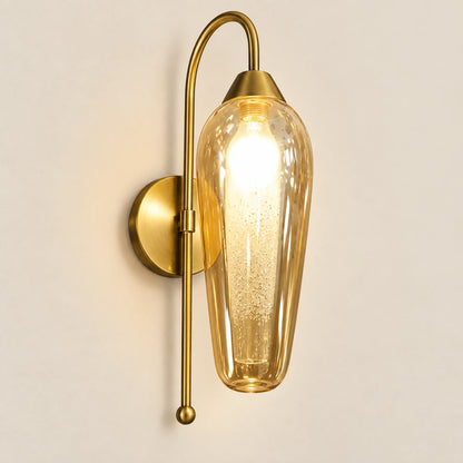 Amber capsule glass wall sconce with curved antique-brass arm
