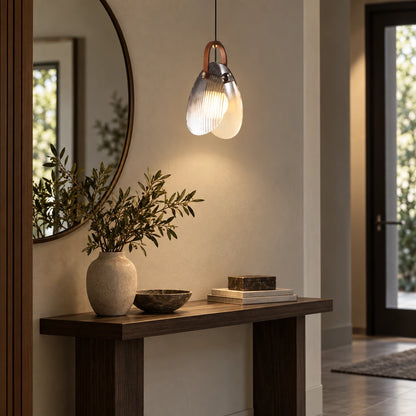 Single double-glass teardrop pendant above an entryway console