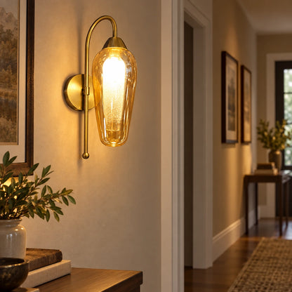 Amber capsule glass wall sconce illuminating a hallway