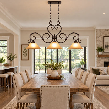 Antique-scroll three-shade linear pendant in an open-plan dining room