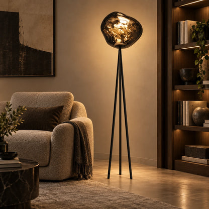 Smoke globe tripod floor lamp beside a bookshelf and chair