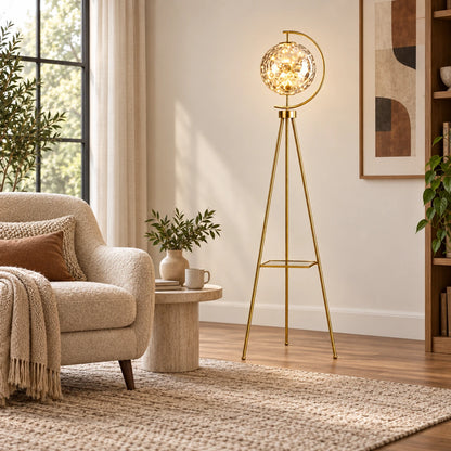 Globe tripod floor lamp at scale beside a reading chair