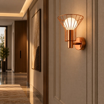 Rose-gold wire-cage globe wall light in a hallway