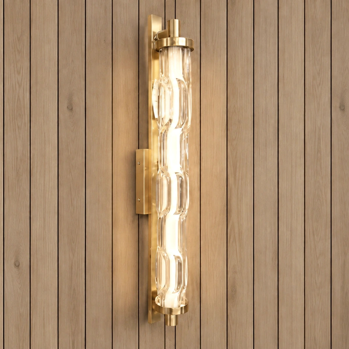 Sculpted clear-glass gold wall light illuminated