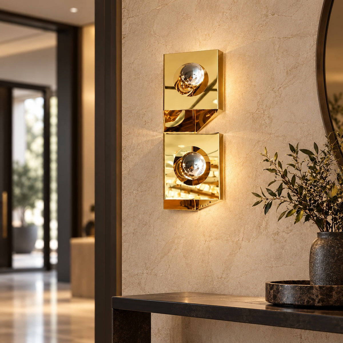 Twin-globe polished gold wall light in a contemporary entry hall