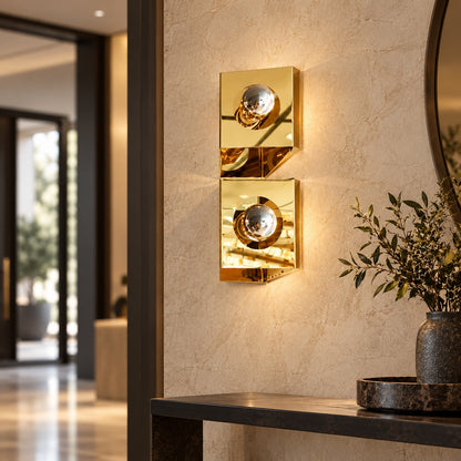 Twin-globe polished gold wall light in a contemporary entry hall