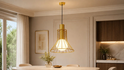 Solenne gold wire pendant softly illuminated above a dining table