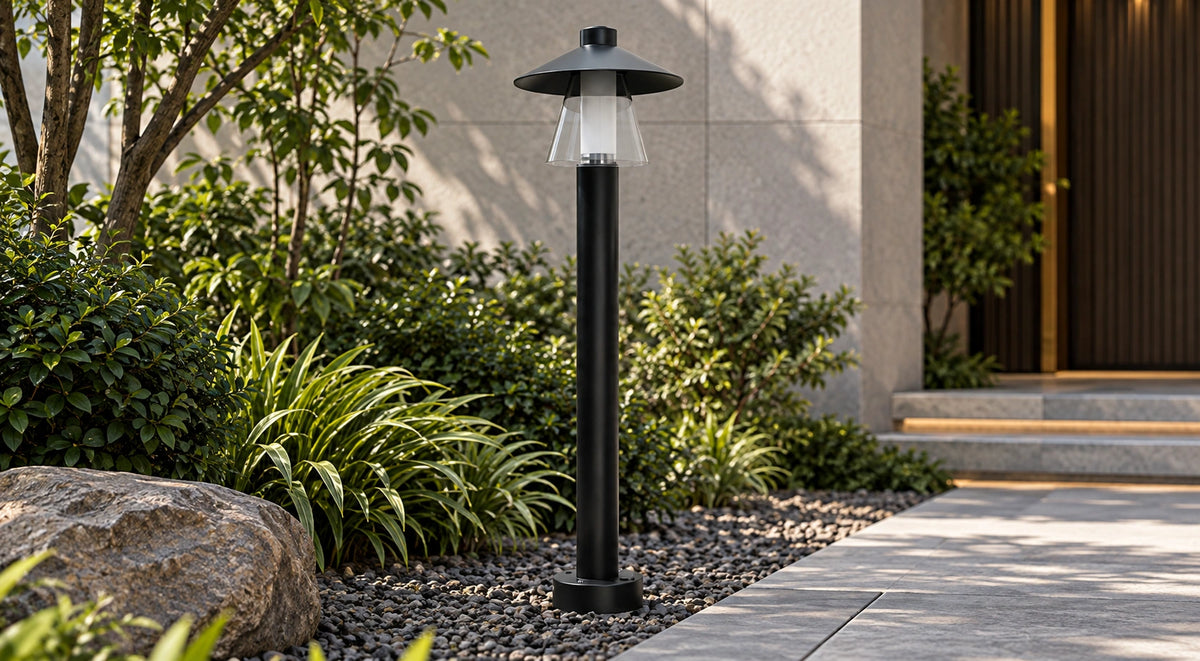 Halo Lantern matte-black bollard light beside a modern garden path by day