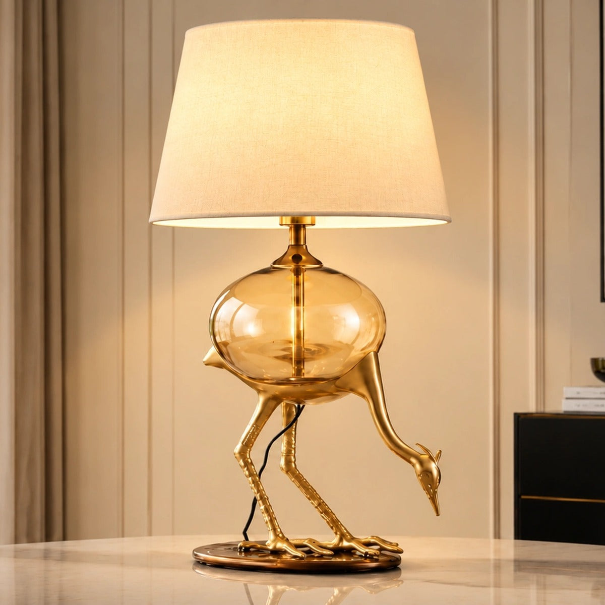 Aurelia gold-tone crane table lamp illuminated in a bright interior
