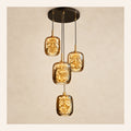 Four-light amber glass cluster pendant on a warm studio background