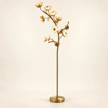 Sculptural floral branch floor lamp on a warm ivory background