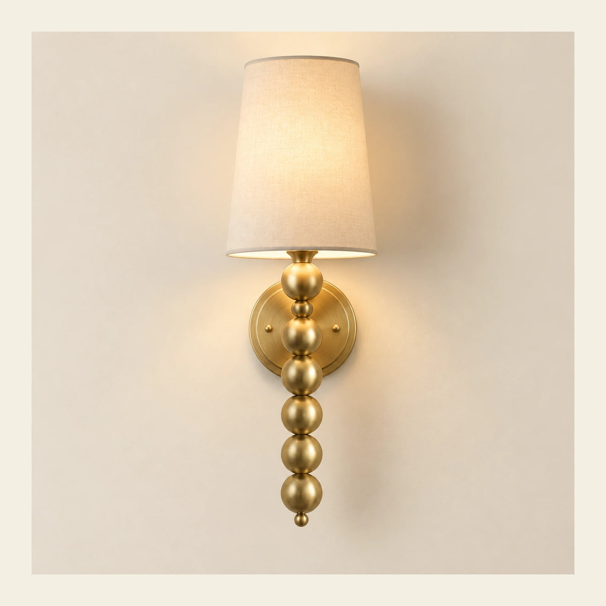 Beaded-stem tapered-shade wall sconce on a warm studio wall