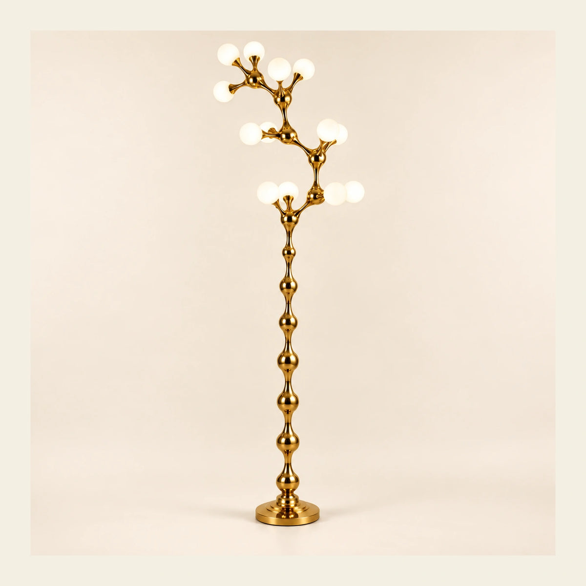 Sculptural gold vine floor lamp on a warm studio background