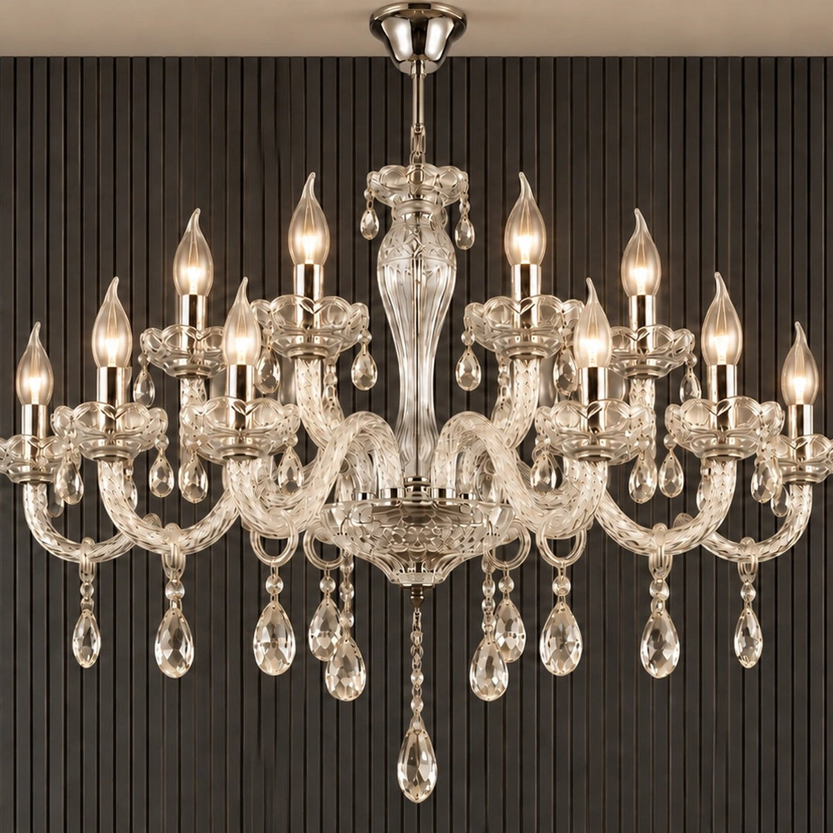 Twelve-light clear crystal chandelier illuminated against a dark fluted wall
