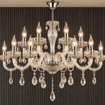 Twelve-light clear crystal chandelier illuminated against a dark fluted wall