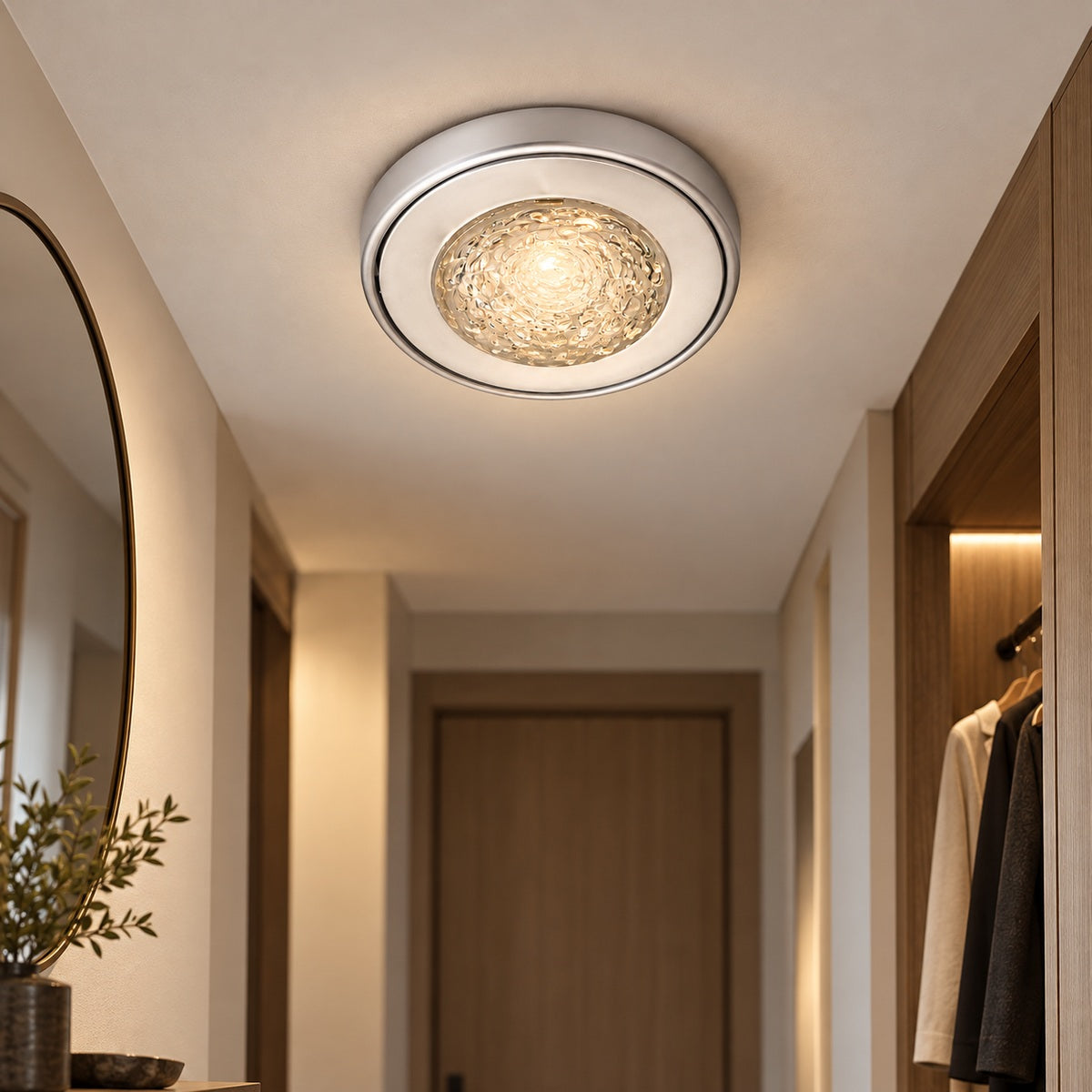 Compact silver flush-mount ceiling light in an entry corridor