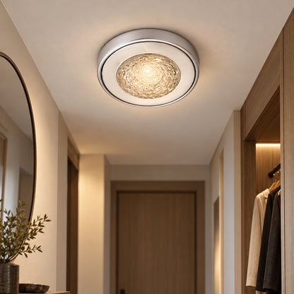 Compact silver flush-mount ceiling light in an entry corridor